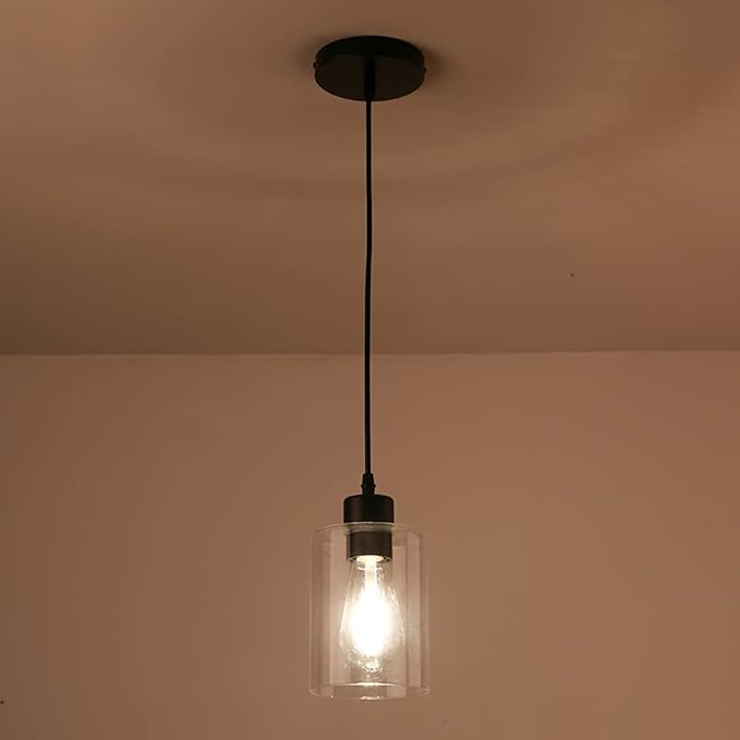 Pendant light with clear glass shade and visible bulb against a beige wall and ceiling.