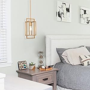 Neatly made bed with gray bedding and pillows in a bedroom setting.